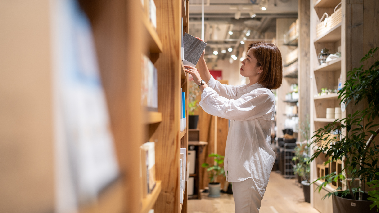 書店にある数多くの本から、好みの本を選んでいる人の写真
